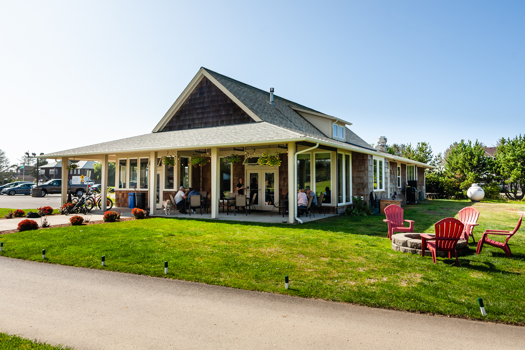 A dog lounges near guests on The Cove’s sunny patio, highlighting the restaurant’s pet-welcoming charm and laid-back setting in Long Beach Washington